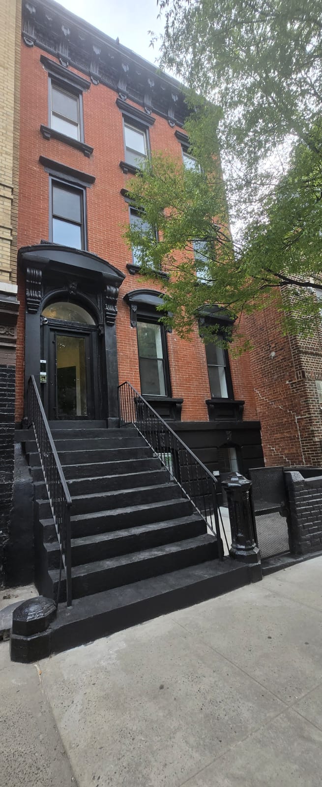 Completed Brooklyn brownstone exterior with restored black stoop, entry surround and facade details